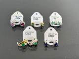 four tags with different colored stones on them on a black surface