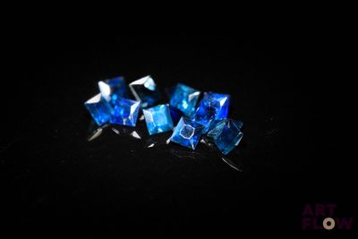 trois morceaux de verre bleu posés sur une surface noire