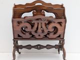 a wooden magazine rack with a carved design on it