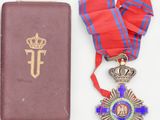 an old book with a cross and a medal next to it