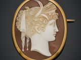 un gros plan sur la tête d'une femme représentée sur une broche en coquillage sculpté