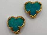 two gold and turquoise heart shaped earrings on a white surface