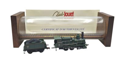 un petit train miniature posé à côté d'un paquet de cigarettes