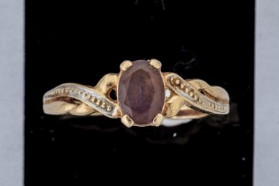une photo d'une bague en or sertie d'une pierre violette