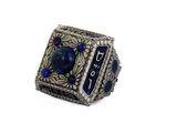Gros plan sur une bague ornée d'une pierre bleue