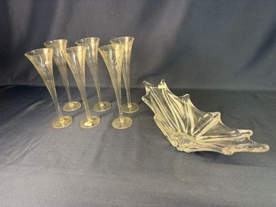 quatre vases en verre transparent et un bol posés sur un tissu bleu