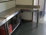 a kitchen with a sink, counter, and shelves in it