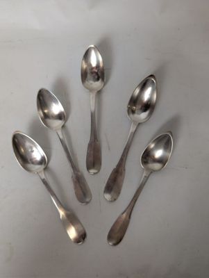 six silver spoons are arranged in a circle on a white surface