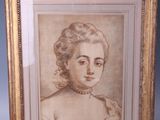 an old picture of a woman in a white dress is on a wooden easel