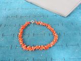 orange coral beaded bracelet with a silver clasp on a blue background