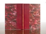 two red books sitting on top of a table next to each other