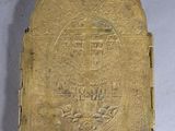 an old brass book with a cross on it sitting on a table
