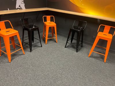 quatre tabourets orange posés dans un coin de la pièce