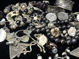 un tas de bijoux en argent posés sur une surface noire