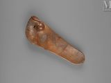 an old wooden object with writing on it on a gray surface