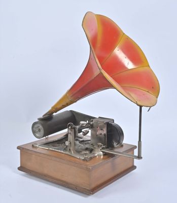 un gramophone rouge et jaune posé sur un socle en bois