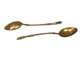 pair of antique brass spoons on a white background