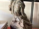 a statue of a man sitting on top of a book