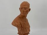 un petit buste d'homme en argile sur fond blanc