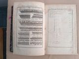 an old book open on a table with a drawing on it