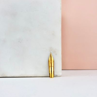 une balle en or posée sur un bloc de marbre