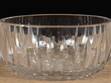 a glass bowl on a table with a black background