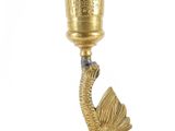 a gold colored candle holder with a dragon on top of it