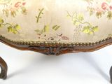une chaise dont l'assise est recouverte d'un tissu à motifs floraux