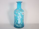 un vase en verre bleu orné d'une image représentant une femme