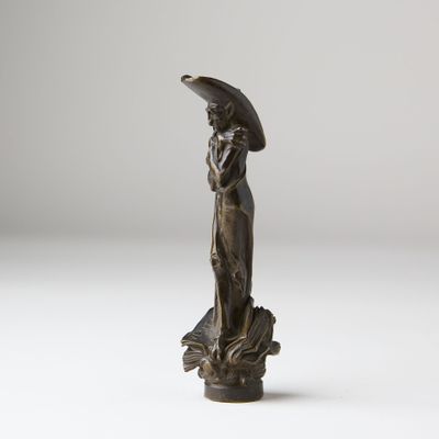 an antique bronze statue of a woman holding an umbrella