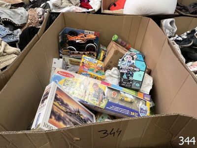 une boîte en carton remplie de jouets et de livres dans une pièce