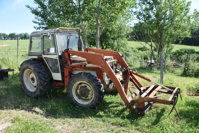 a small tractor that is parked in the grass