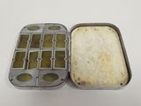 a tin with a sandwich inside of it on a table