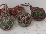 trois boules de Noël en verre vertes et rouges posées sur une table blanche