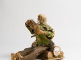 a figurine of a man sitting on top of a tree stump