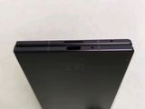 the back of a black cell phone sitting on top of a table