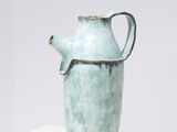 un vase bleu posé sur une table blanche
