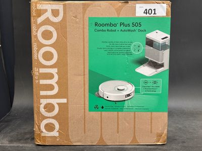 packaging of a roomba plus vacuum with a box on a table
