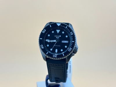 un gros plan d'une montre noire posée sur un socle