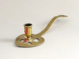 un petit porte-pipe en laiton posé sur une surface blanche