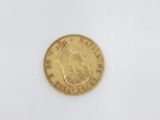 a close up of a gold coin on a white surface