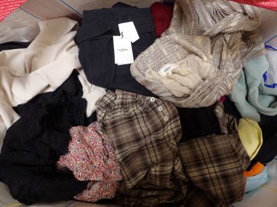 a pile of clothes in a basket with a tag on it