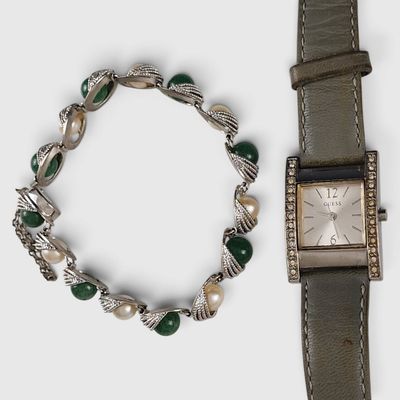 two watches and a bracelet on a white surface