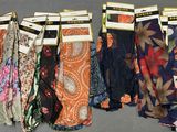 many different types of scarves on display in a store