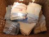 un panier en osier rempli de serviettes et de serviettes de table pliées