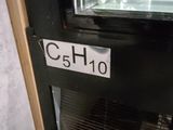 a sign that says c5h10 in front of a refrigerator