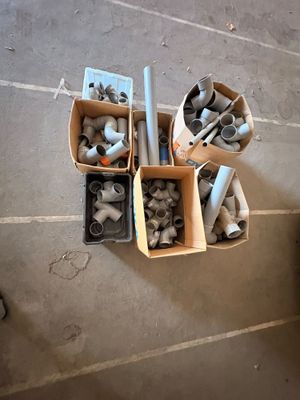 quatre cartons de raccords de tuyauterie posés par terre