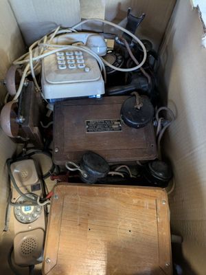 une boîte remplie de vieux téléphones et d'autres appareils électroniques