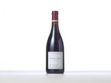 a bottle of red wine sitting on top of a white counter