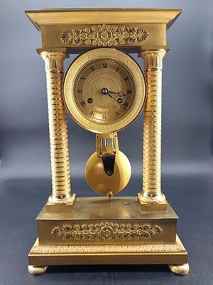 Pendule portique à deux colonnes en bronze doré à décor de p…